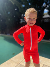 Child near a swimming pool wearing UPF50 + Swimwear for Babies and Kids - Sun safe Swimuit in Flaming Orange